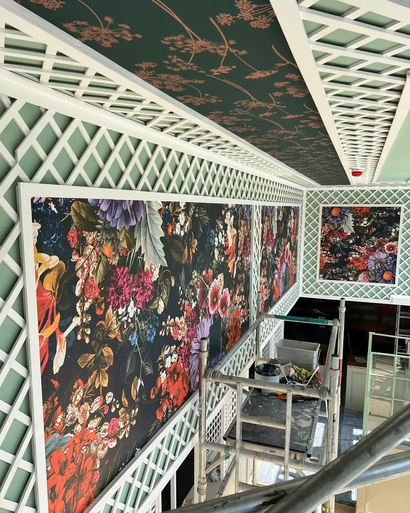 Decorative white timber lattice panelling fitted around a double-height interior, with framed floral wall panels
